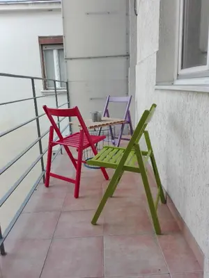 two chairs and a table on a balcony at Centrala Apartment in Belgrade