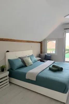 a bedroom with a large bed with blue pillows at Barrique apartmani sa zatvorenim bazenom in Smederevo