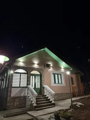 a house with a green door and stairs at night at Barrique apartmani sa zatvorenim bazenom in Smederevo