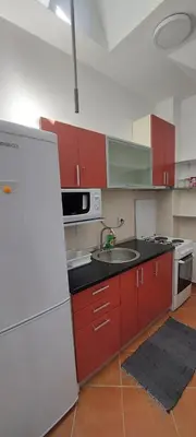 a kitchen with red cabinets and a white refrigerator at Michigan Hill Apartmant in Belgrade