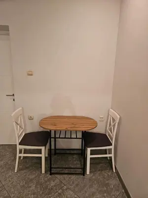 a wooden table and two chairs in a room at Prime Location Studio in Belgrade