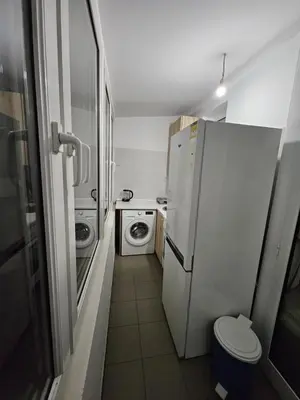 a small bathroom with a refrigerator and a washing machine at Prime Location Studio in Belgrade