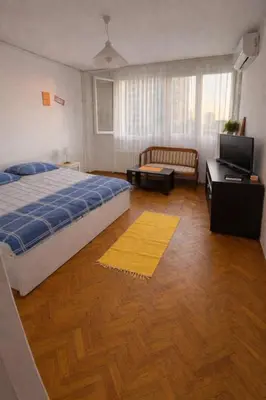 a bedroom with a bed and a couch and a television at Summer Edition Belgrade in Belgrade