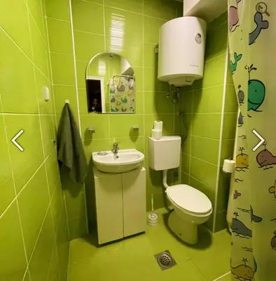 a green bathroom with a toilet and a sink at Summer Edition Belgrade in Belgrade