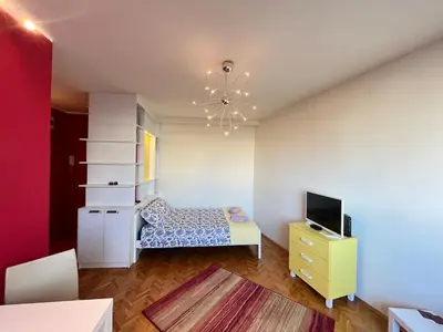 a living room with a bed and a television at Bright modern downtown studio in Belgrade