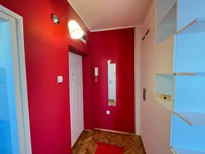 a red hallway with a white door and a red wall at Bright modern downtown studio in Belgrade