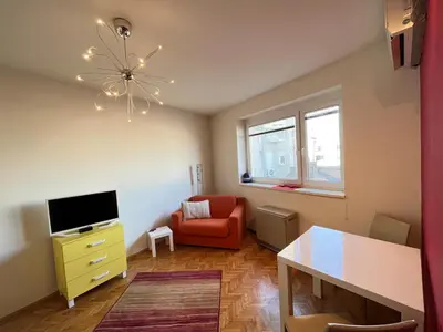 a living room with a red chair and a television at Bright modern downtown studio in Belgrade
