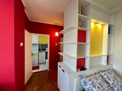 a room with red walls and white shelves at Bright modern downtown studio in Belgrade