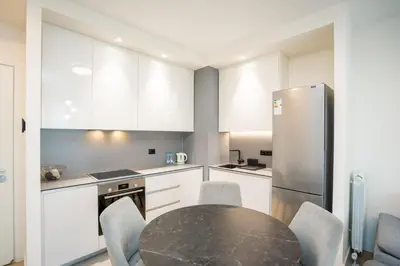 a kitchen with a table and chairs and a refrigerator at Velora BW Metropolitan in Belgrade