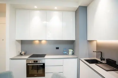 a kitchen with white cabinets and a stove top oven at Velora BW Metropolitan in Belgrade