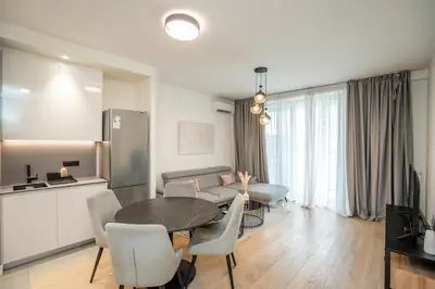 a kitchen and a living room with a table and chairs at Velora BW Metropolitan in Belgrade