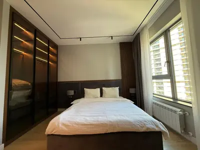 a bedroom with a large bed and two windows at BW Home in Belgrade