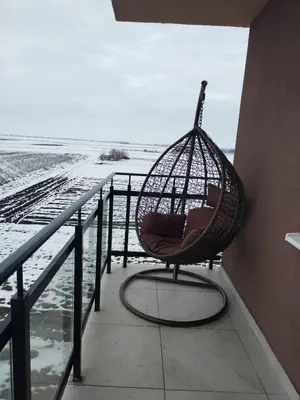 a hammock sitting on a balcony overlooking the ocean at Apartman Nina Banovci in Novi Banovci