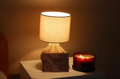 a table with a lamp and a candle on it at Apartman Nina Banovci in Novi Banovci