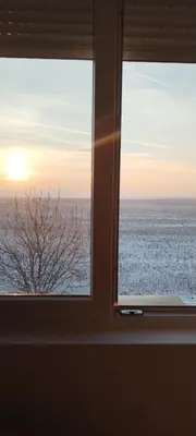 a window with a view of the ocean seen through it at Apartman Nina Banovci in Novi Banovci