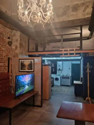 a living room with a television and a chandelier at Bar apartment in Belgrade
