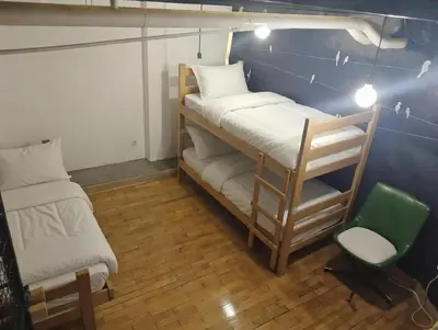 a room with two bunk beds and a chair at Bar apartment in Belgrade