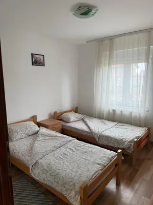two twin beds in a room with a window at Elegance Apartman in Belgrade