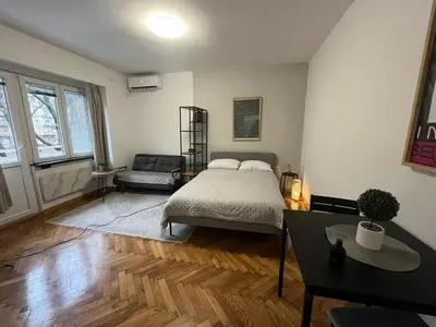 a bedroom with a bed and a couch in it at Apartman General in Belgrade