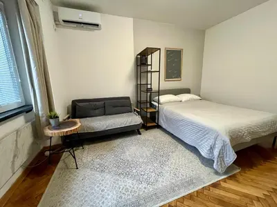 a bedroom with a bed and a chair in it at Apartman General in Belgrade