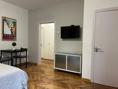 a bedroom with a bed and a television on a wall at Apartman General in Belgrade