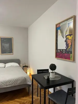 a bedroom with a bed and a table with a table sidx sidx sidx at Apartman General in Belgrade