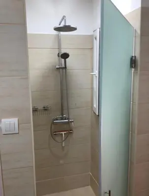 a shower in a bathroom with a glass door at Apartman General in Belgrade