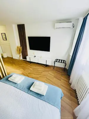 a living room with a bed and a flat screen tv at Fontana Lux Apartment in Belgrade