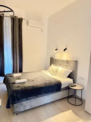 a bedroom with a large bed with two towels on it at Natalie's Prestige in Belgrade