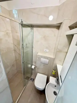a bathroom with a shower and a toilet and a sink at Natalie's Prestige in Belgrade