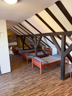 a row of benches in a room with a ceiling at Pecinci Hostel in Pećinci