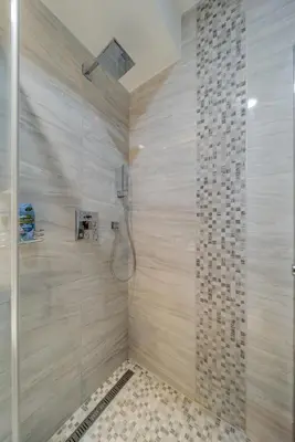 a bathroom with a shower with a glass wall at COZY Urban Heaven in Belgrade