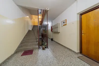 a hallway with a staircase and a wooden door at COZY Urban Heaven in Belgrade