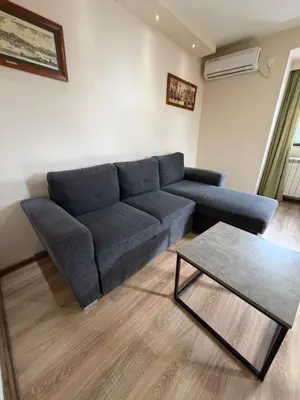 a living room with a blue couch and a table at Knez Mihailova street in Belgrade in Belgrade