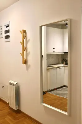 a mirror on a wall next to a kitchen at Dok city apartman in Belgrade