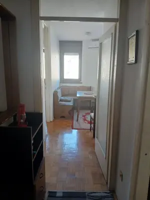 a room with a hallway with a table and a couch at Bezanija86 in Belgrade