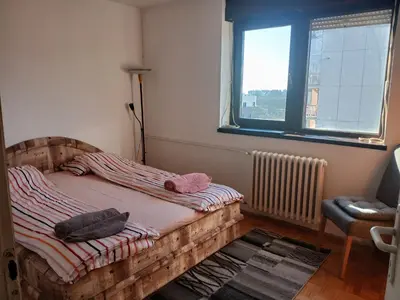 a bedroom with a wooden bed and a window at Bezanija86 in Belgrade