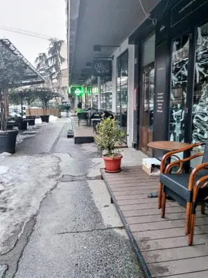 an empty street with benches and tables outside a store at Vracar Cozy Nook in Belgrade