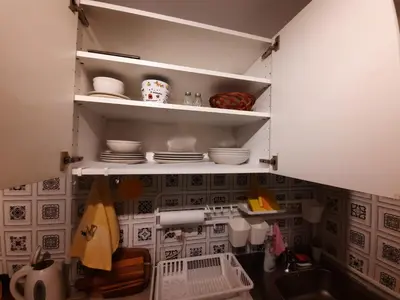 a kitchen with a sink and shelves with dishes at Comfort Studio in Belgrade