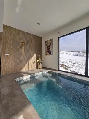 a swimming pool in a house with a large window at Lake & Pool Paradise in Karaula