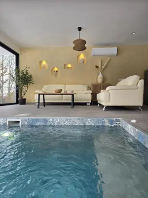 a swimming pool in a living room with a couch and a table at Lake & Pool Paradise in Karaula