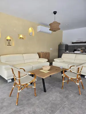 a living room with a couch and a table and chairs at Lake & Pool Paradise in Karaula