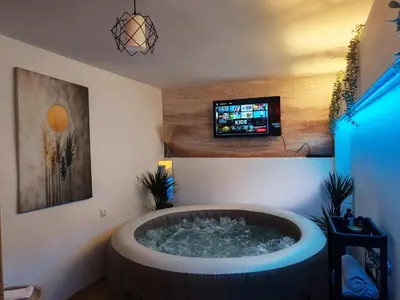 a hot tub in a room with a tv at Jacuzzi Sauna - Besplatan parking in Belgrade