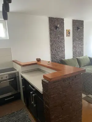 a kitchen with a counter top and a living room at Prvi maj in Ub