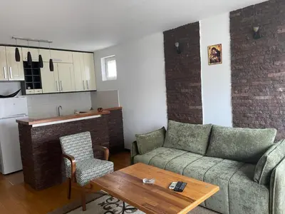 a living room with a couch and a table and a kitchen at Prvi maj in Ub
