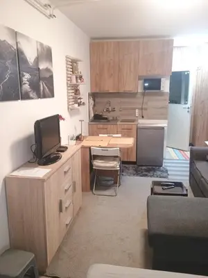 a kitchen with a desk with a television and a couch at River Sava apartman in Belgrade
