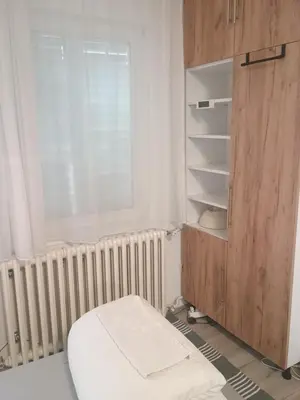 a room with a bed and a cabinet and a window at River Sava apartman in Belgrade