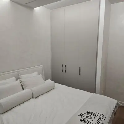 a bedroom with a white bed with white cabinets at BW Exclusive apartment in Belgrade