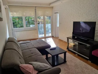 a living room with a couch and a flat screen tv at Apartment MHarmony#Vracar in Belgrade