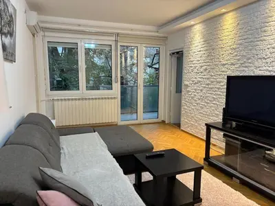 a living room with a couch and a flat screen tv at Apartment MHarmony#Vracar in Belgrade